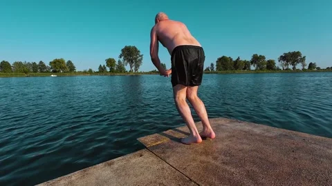 Clumsy heavyset man jumping headfirst into cold refreshing water. Bald chubby Stock Footage 303497575