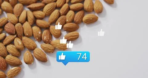 Cluster of almonds on white tabletop, showing thumbs-up icons and notification Stock Photos