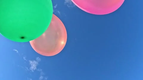 Cluster of colorful balloons floating in clear summer sky Stock Footage 316877164