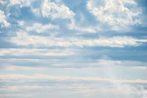 A cluster of cumulus thunderclouds in a bright blue sky during the daytime. Stock Photos