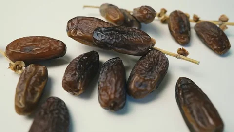 Cluster of Dried Dates on Light Surface, A cluster of dried dates on a ligh.. 動画素材 304974881