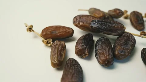 Cluster of Dried Dates on Light Surface, A cluster of dried dates on a ligh.. Видео 304974929