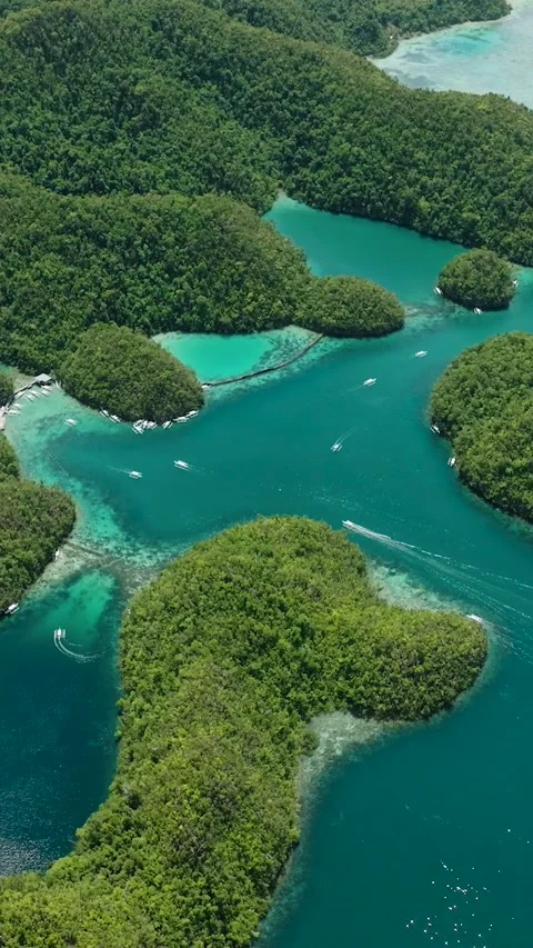 Cluster of green islets with turquoise lagoons and boats in blue sea. Siargao Stock Footage 321104430