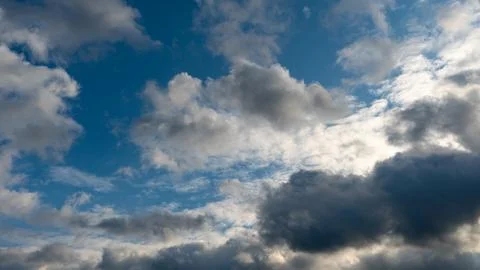 A cluster of light and fluffy clouds interspersed with dark gray clouds. Befo Stock Photos