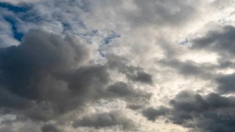 A cluster of light and fluffy clouds interspersed with dark gray clouds. Befo Stock Photos