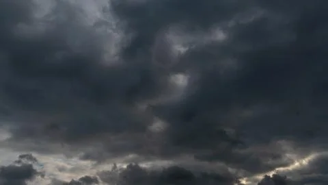 A cluster of light and fluffy clouds interspersed with dark gray clouds. Befo Stock Photos