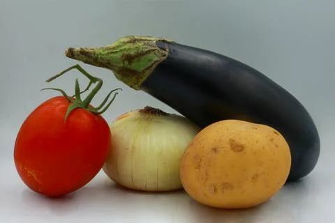 A cluster of a single vine-ripened red tomato, a whole white onion, Stock Photos