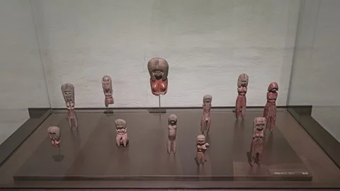 Cluster of Small Reddish Clay Figurines on Dark Glass, Casa del Alabado, Ecuador Stock-Footage 331493650