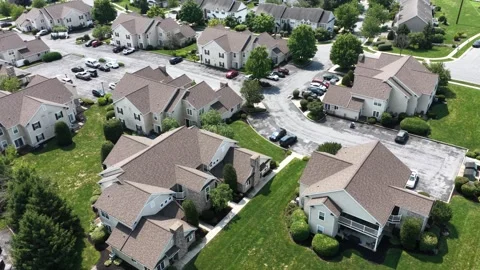 Cluster of townhome rooftops with tan asphalt shingles and steep gables Stock Footage 342810759