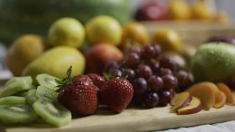 Cluster of various fruit on cutting board in kitchen - closeup shot Stock Footage 341233674