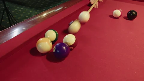 Clustered spheres distribute energetically over red felt surface of table Video stock 329193002