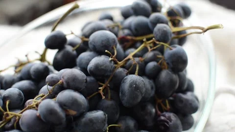 Clusters of ripe blue grapes in a transparent glass tray Stock Footage 327853938
