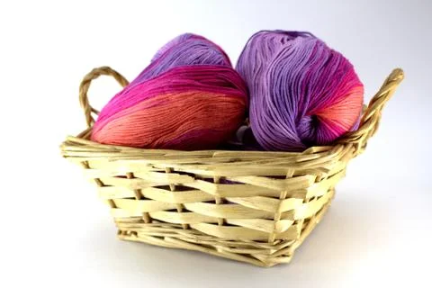 Clusters of sectional yarn for needlework in a wicker basket Stock Photos