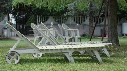 Cluttered area with abandoned dirty plastic chairs and chaise loungers Video stock 288452867