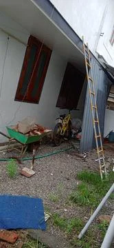 Cluttered backyard with tools and bicycle Fotos Stock