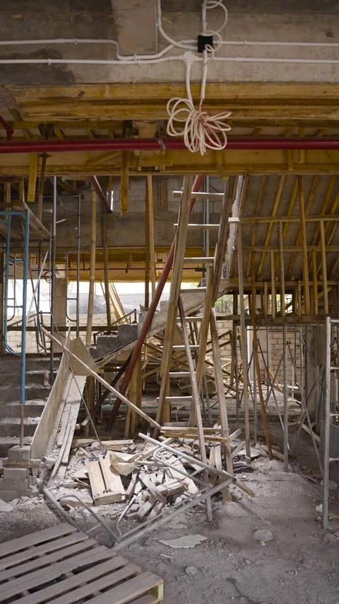 Cluttered construction site interior with scaffolding, wooden planks, and debris Stock Footage 270360475