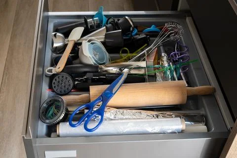 Cluttered kitchen drawer organized with various cooking utensils Stock Photos