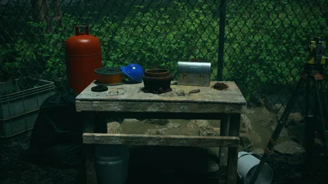 A cluttered outdoor work area at night, with a table, ladder, and various tools Video stock 309071386