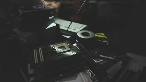 A cluttered workspace filled with computer parts and tools at night Stock Footage 304467629