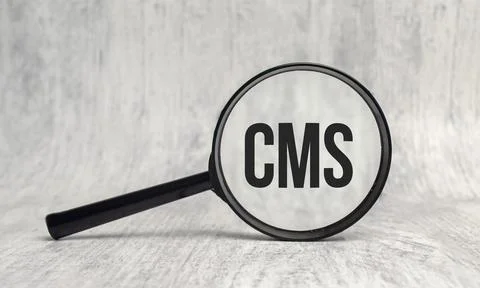 CMS. Content Management System, word under magnifying glass Stock Photos