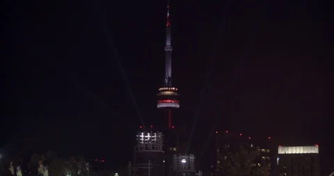CN Tower surrounded by spotlights from the CNE at night 스톡 동영상 115541826