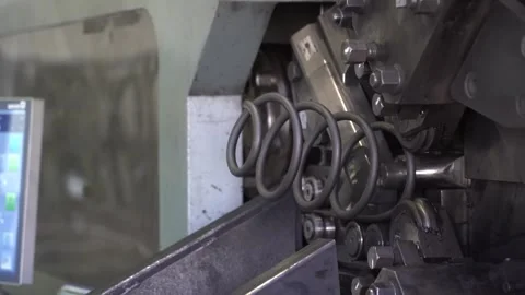 CNC coiling machine bends steel rod into automotive coil spring in factory Vídeos de archivo 347719846