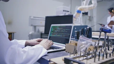 Cnc engineer in white coat working on laptop in lab Stock Footage 111639204