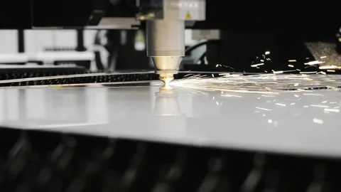 CNC laser cutting machine cutting sheet metal with sparks. Stockbeeldmateriaal 347776626