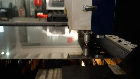 Cnc laser cutting machine head processing sheet metal with sparks in factory Stock Photos