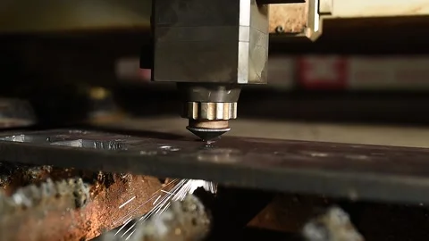 A CNC laser cutting machine precisely cuts through a metal sheet, producing Video stock 290795458