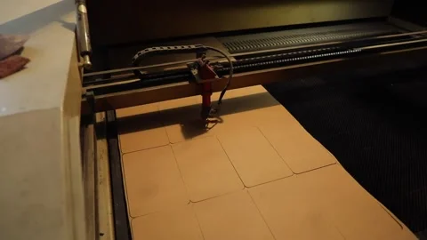 A CNC laser machine cuts a part from cardboard. Stock Footage 233071643