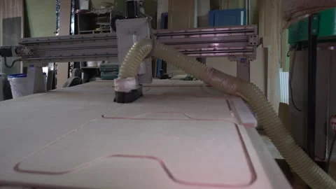 A CNC machine carefully cuts foam sheets with precision in a workshop. The setup Stock Footage 332227504