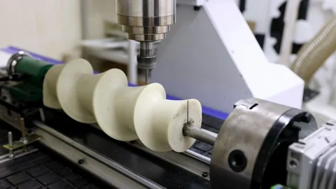 A CNC machine is carving a complex spiral shape from a plastic block Stock Footage 314985027