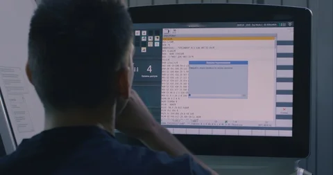 CNC machine control screen. a man works on a CNC machine monitor. Filmed on Video stock 129079736