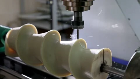 CNC machine drilling and milling a plastic or polymer part, creating an ind.. Stock Footage 317916977