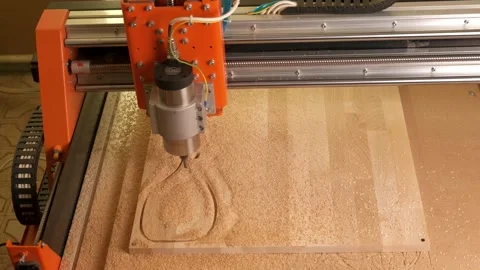 The CNC machine is finishing its work. The carpenter blows off the shavings Stock Footage 143913782