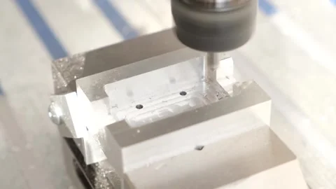 CNC mill drills precise holes into a metal block Stock Footage 314815790