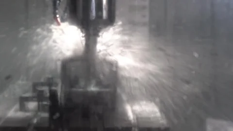 CNC milling machine grinds a metal part with cooling Stock Footage 120533542