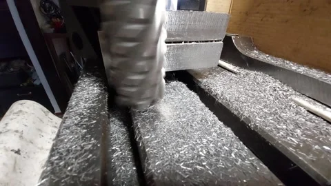 CNC milling machine head cutting steel block with metal shavings close-up Stock Footage 335572481