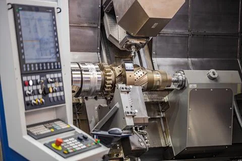 CNC milling machine machining large metal gear component in factory. Stock Photos