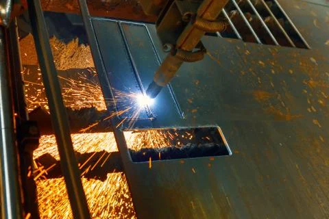 CNC plasma cutting machine cuts a metal sheet. Many sparks and incandescent Stock Photos