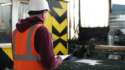 A CNC plasma cutting machine engineer makes notes and calculations in a journal. Video stock 276549446