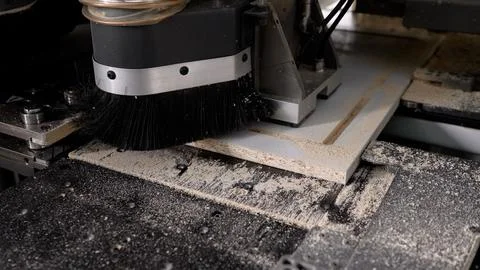 Cnc router machine processing wooden panel with sawdust Stock Photos