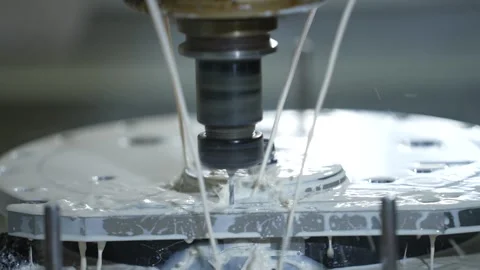 CNC turning machine high precision throwing coolant liquid on metal component in Stock Footage 340853532