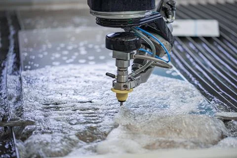CNC waterjet cutting machine processing metal sheet in factory. Foto stock