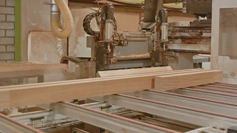 A CNC woodworking machine delivers a cut frame and automatically grabs a fresh Stock Footage 327544961