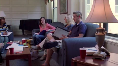 Co-ed college students gathered for group study time in a dorm's common area Stock Footage 59250760
