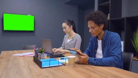 Co-workers browse internet while sitting in the office Stock Footage 107389899