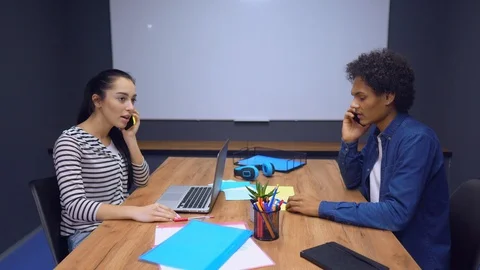 Co-workers communicate with clients while sitting in a conference room Stock Footage 107404549