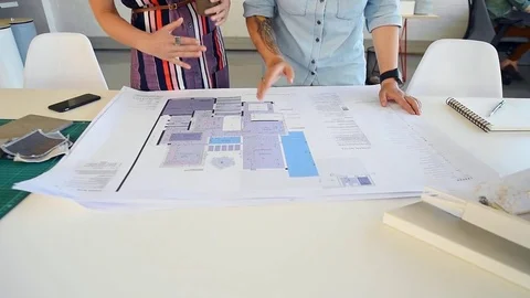 Co-workers with floor plans layouts in architecture firm Video stock 73312707